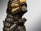 a close up of a statue of a man with a bird on his head