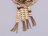 gold plated necklace with red stone and tassels
