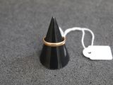 un cône noir orné d'un anneau doré, à côté d'une étiquette de prix