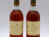 deux bouteilles de vin posées l'une à côté de l'autre sur une surface blanche