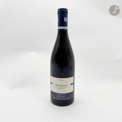une bouteille de vin rouge posée sur une table blanche