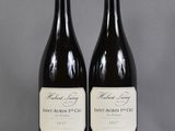 two bottles of wine sitting on top of a table next to each other