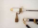 a gold keychain with a tassel on it next to a pair of scissors