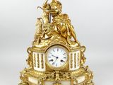 une horloge en or surmontée d'une statue