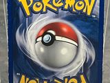 a pokemon card in a plastic case on a table