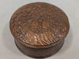 une photo d'une boîte en bois ornée de sculptures, posée sur une table