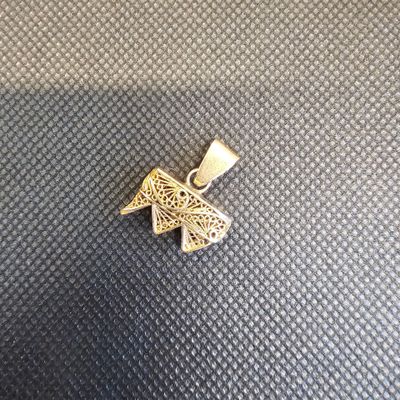 un petit pendentif en forme de papillon doré sur fond noir
