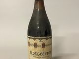 une vieille bouteille de vin posée sur une table blanche