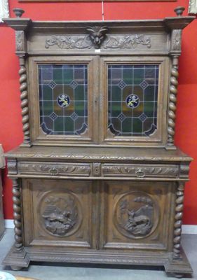 a wooden cabinet with two glass doors on top of it