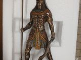 a statue of an egyptian warrior holding a staff