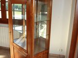 a wooden cabinet with a glass door in a room