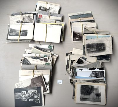 a pile of old photos on a table with a notepad