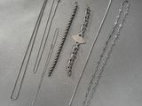 une collection de colliers et de bracelets en argent posés sur une table