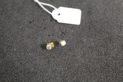 une étiquette et une paire de boucles d'oreilles posées sur une table