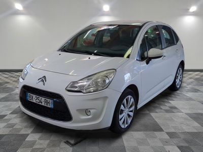 la petite voiture blanche est garée sur un sol en damier