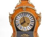 une horloge posée sur un support sur une surface blanche
