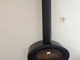 a black stove with a stack of wood in front of it