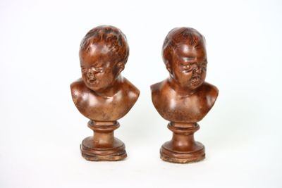 paire de bustes anciens en bois représentant des enfants, posés sur des socles