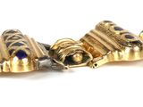 a close up of a gold bracelet with blue stones