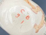 a close up of a vase with a dog design on it