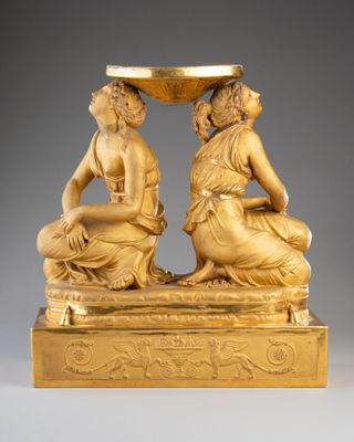 une image représentant une statue en or de deux femmes portant un bol sur la tête