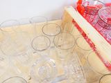 de nombreux verres dans une boîte en bois posée sur une table