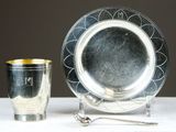 une assiette en argent et une tasse en argent posées sur une table