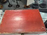 a red box sitting on top of a table next to a lamp