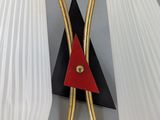 pair of white and gold wall lamps with a red triangle on each of them