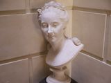 un buste de femme posé sur un socle dans un coin de la pièce