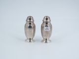 two silver salt and pepper shakers on a white surface
