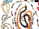 many different colored beads and necklaces laid out on a table