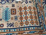 an image of a blue and orange rug on a bed