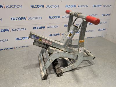 un gros plan d'une machine avec une poignée rouge posée sur le sol