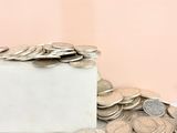 a pile of coins sitting on top of a white box