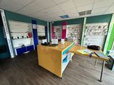 une pièce avec un bureau, des étagères et une imprimante posée dessus