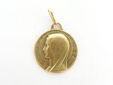 l'image d'une médaille d'or sur laquelle figure le visage d'une femme