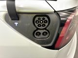 a close up of a car ' s rear end with a plugged in