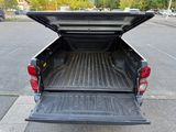 the back end of a truck with its bed open in a parking lot