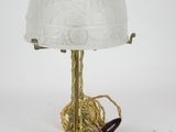 an antique brass table lamp with a glass shade on it