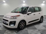 la petite voiture blanche est garée sur un sol en damier