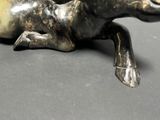 a statue of a horse laying down on a table