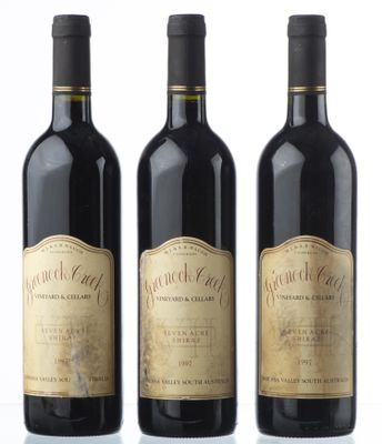 trois bouteilles de vin sont alignées sur une surface blanche