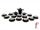 a picture of a black and white tea set with cups and saucers