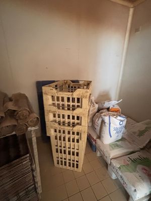 a small room with a bed and a basket on the floor
