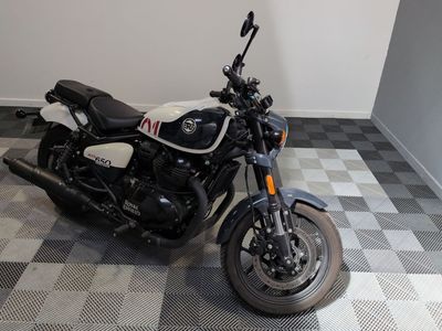 une moto noire et blanche garée sur un sol à damier