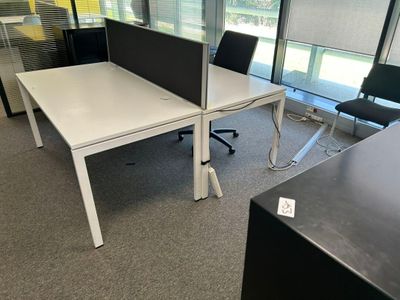 une image représentant un espace de travail en open space avec deux bureaux et une chaise
