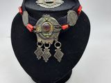 Le collier est en métal et est entouré d'un cordon rouge.