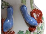two blue birds sitting on top of a vase