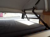 a bed in the back of a camper with a black cover